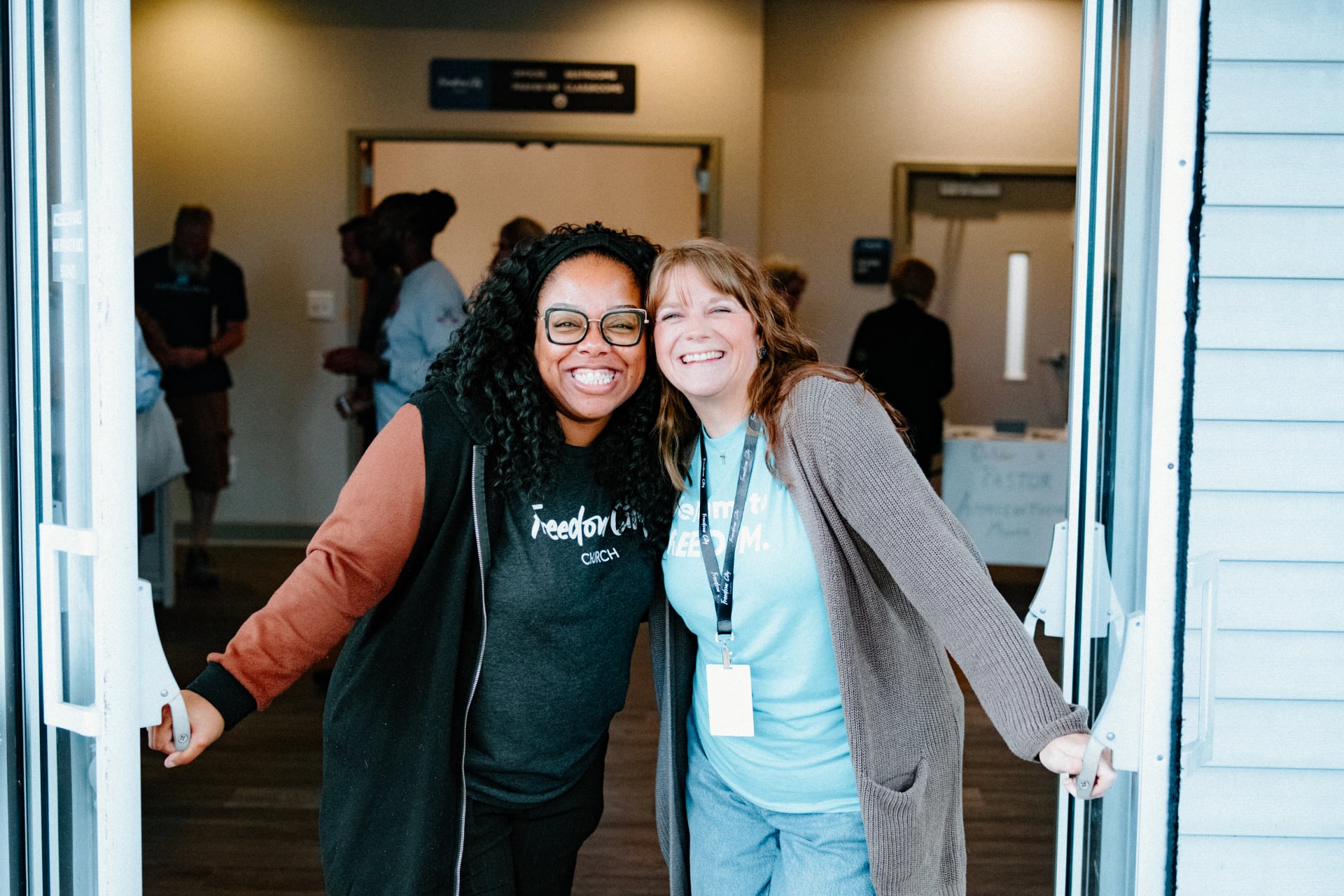 Friends welcoming people at the church doors