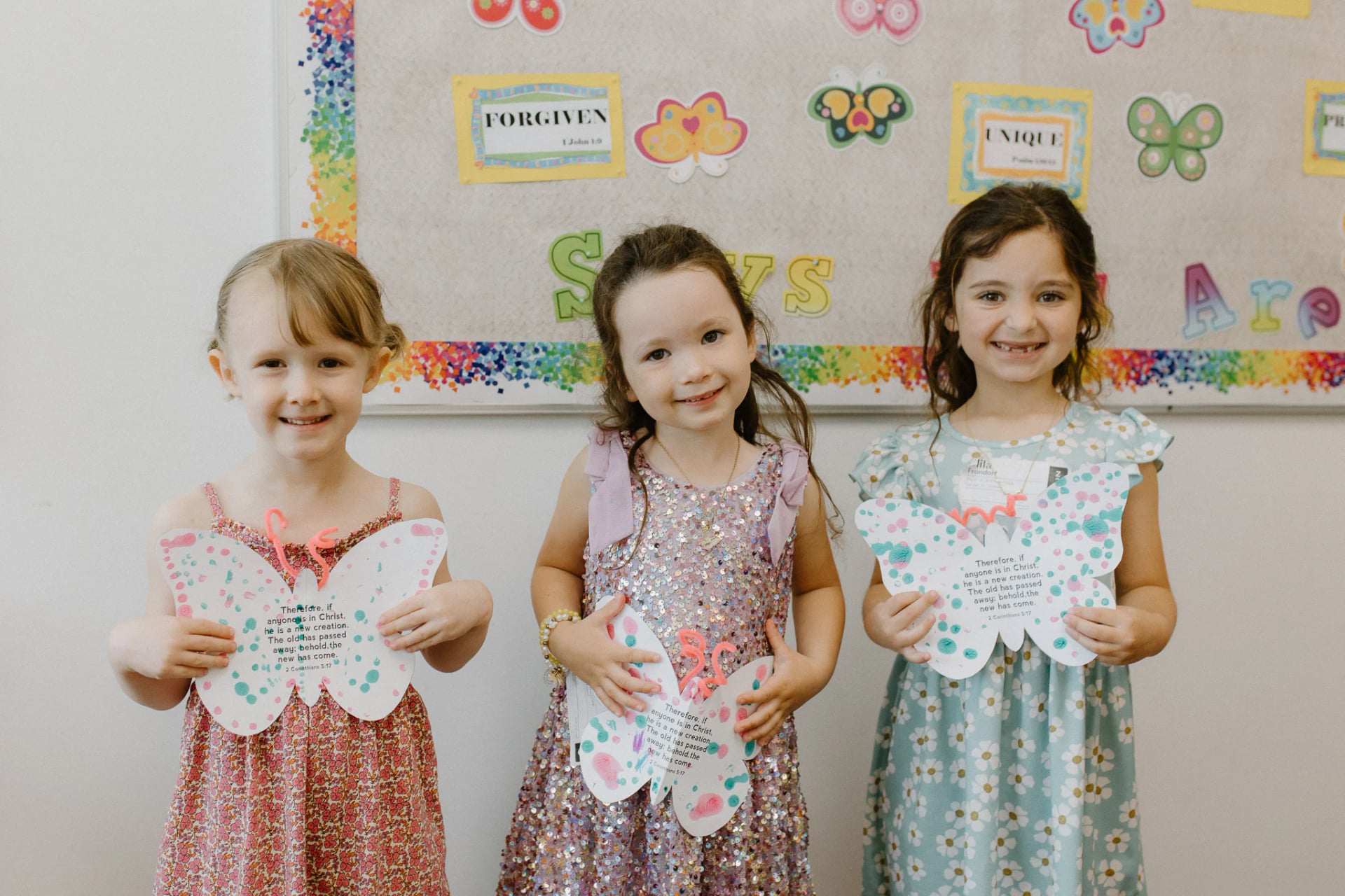 Three girls holding their butterfly crafts