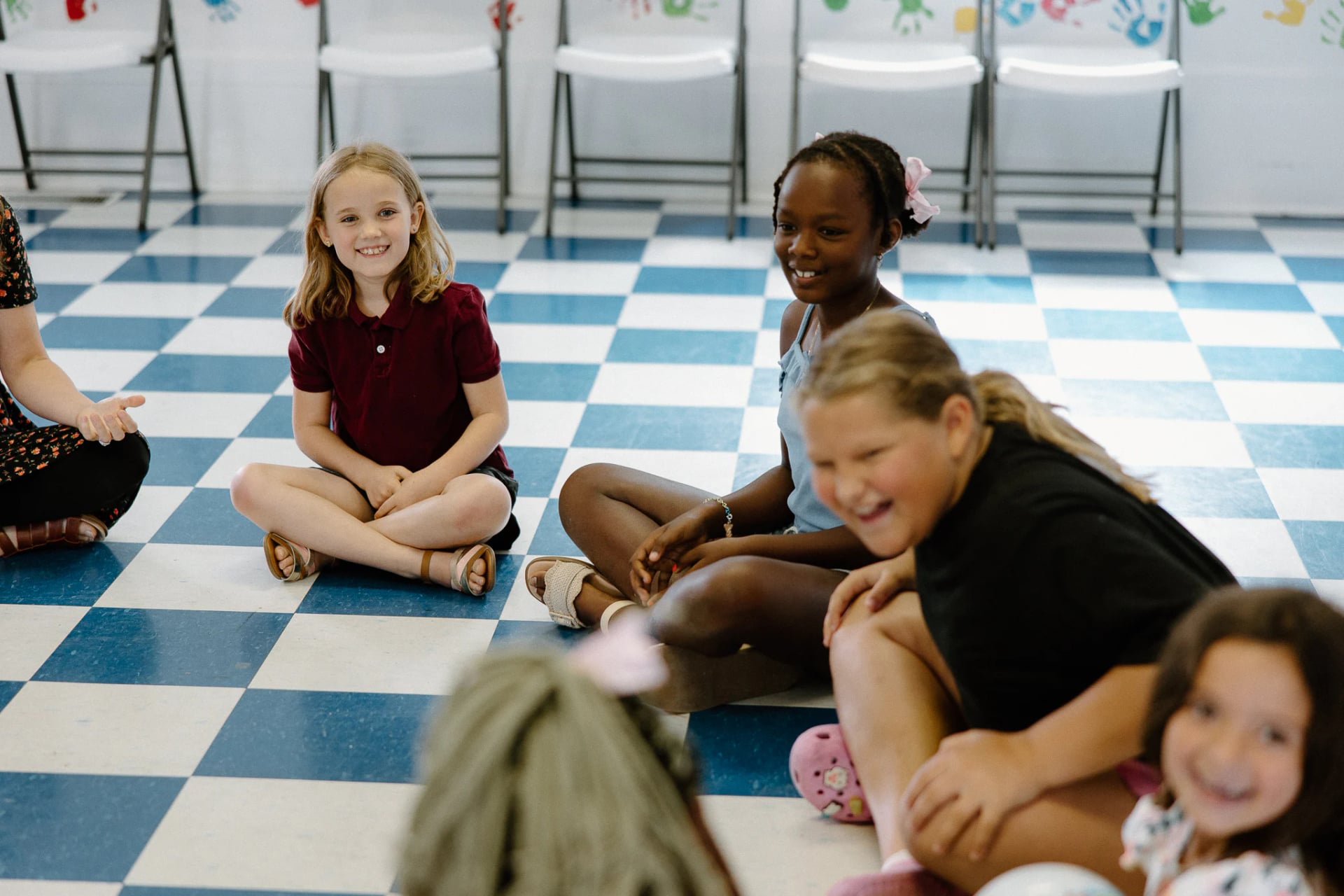 Kids sitting together on a checkered floor, laughing