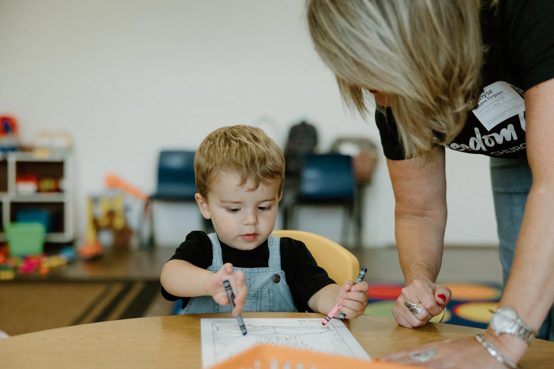 A leader coloring with a toddler